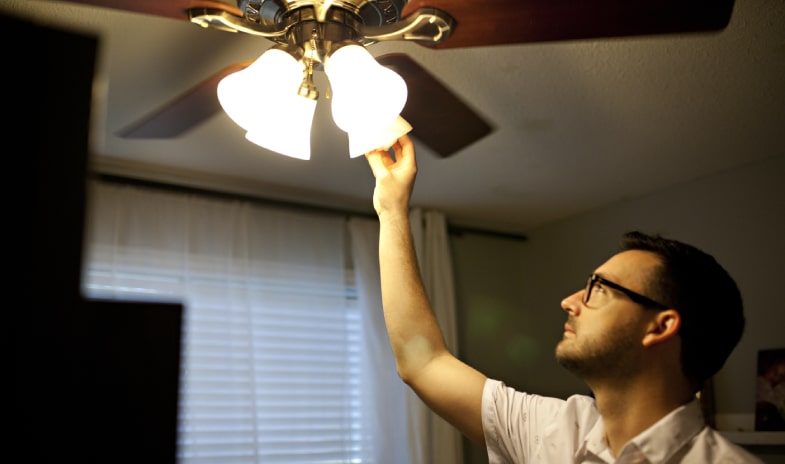 Homeowner checking flickering ceiling light fixture