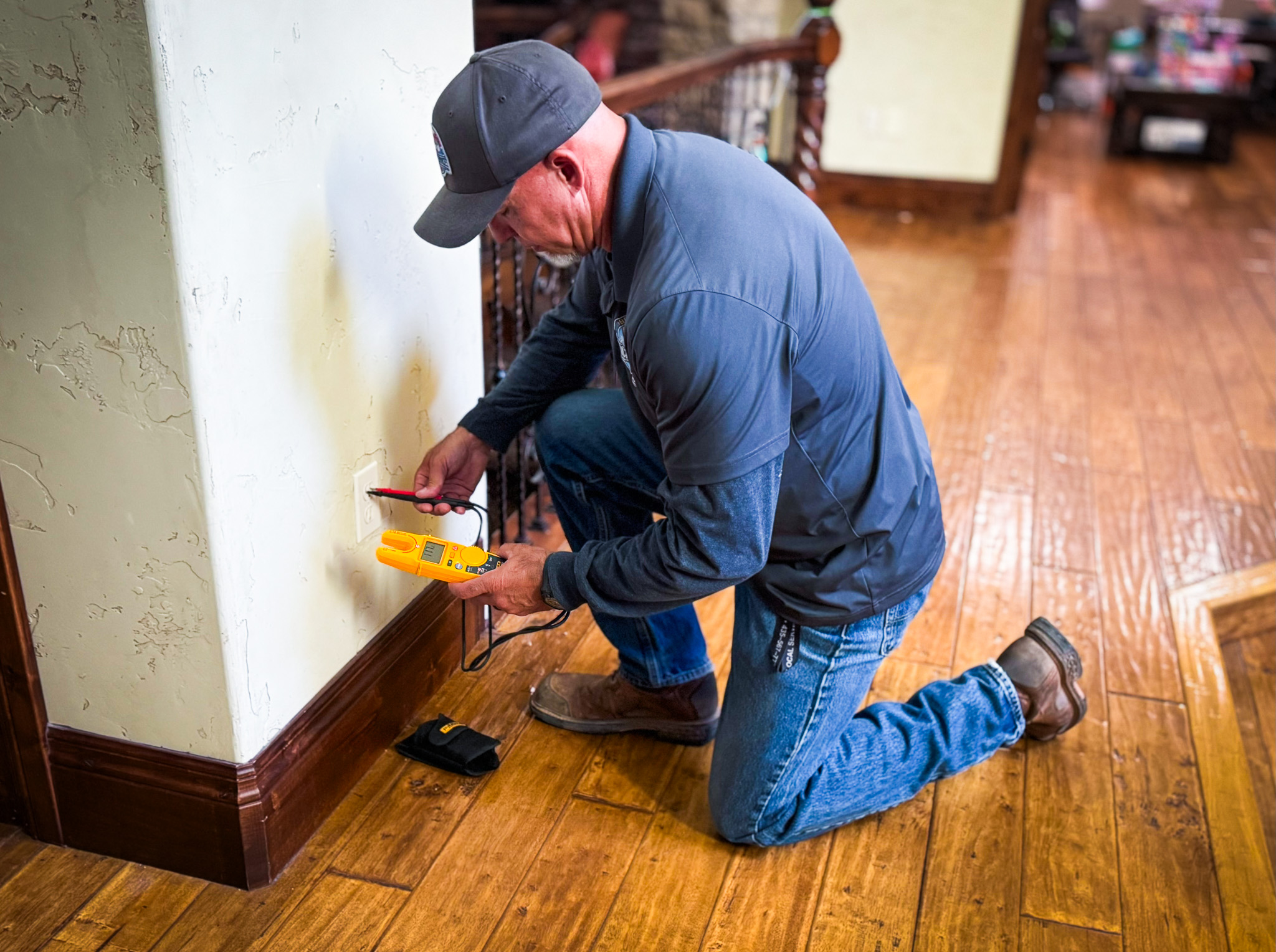 Local Services Inc. electrician testing outlet with Fluke meter