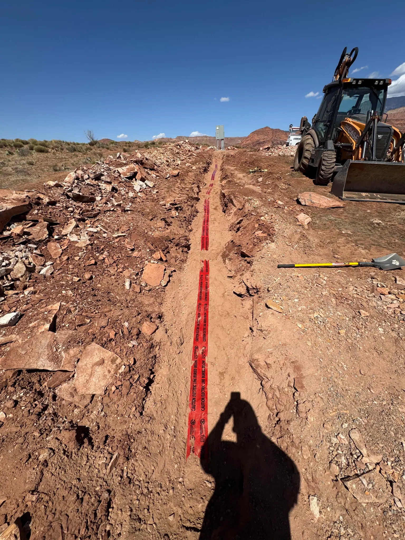 Underground electrical conduit installation with backhoe