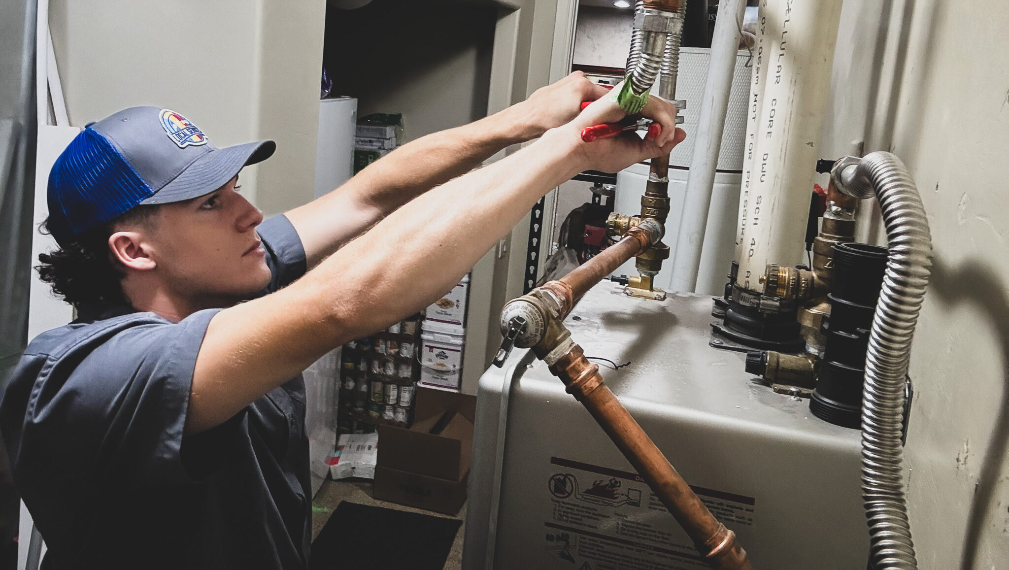 Local Services Inc. plumber working on water heater